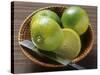 Limes, Two Whole and One Halved in a Small Basket-Eising Studio - Food Photo and Video-Stretched Canvas