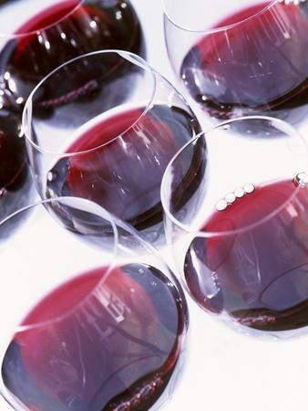 Six Glasses of Red Wine Against White Background