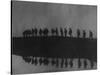Line of Soldiers on Ridge Silhouetted Against Sky Reflected from River Beside Them-null-Stretched Canvas