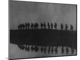 Line of Soldiers on Ridge Silhouetted Against Sky Reflected from River Beside Them-null-Mounted Photographic Print