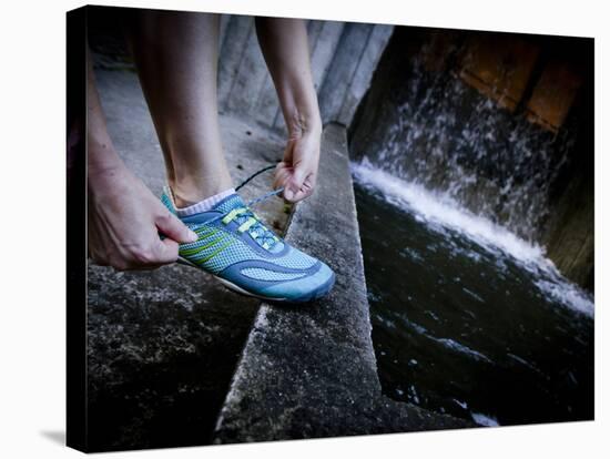 Lisa Eaton Laces Up Her Running Shoe Near a Water Feature at Freeway Park - Seattle, Washington-Dan Holz-Stretched Canvas