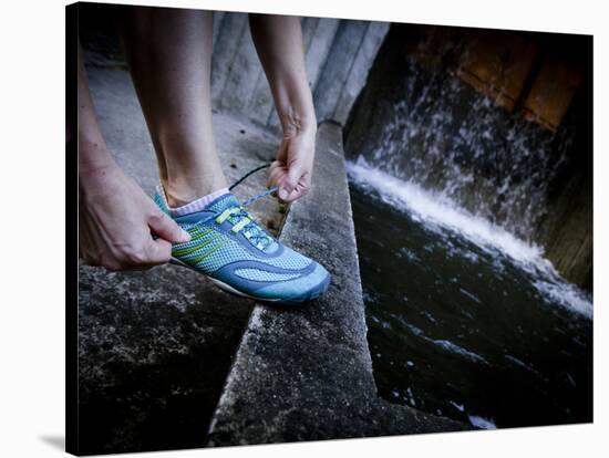 Lisa Eaton Laces Up Her Running Shoe Near a Water Feature at Freeway Park - Seattle, Washington-Dan Holz-Stretched Canvas