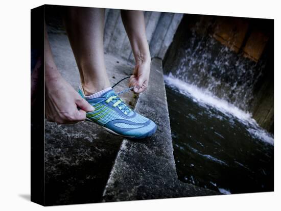 Lisa Eaton Laces Up Her Running Shoe Near a Water Feature at Freeway Park - Seattle, Washington-Dan Holz-Stretched Canvas