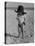 Little Boy at the Beach Wearing a Oversized Cowboy Hat Playing with a Toy Pistol-Ralph Crane-Stretched Canvas