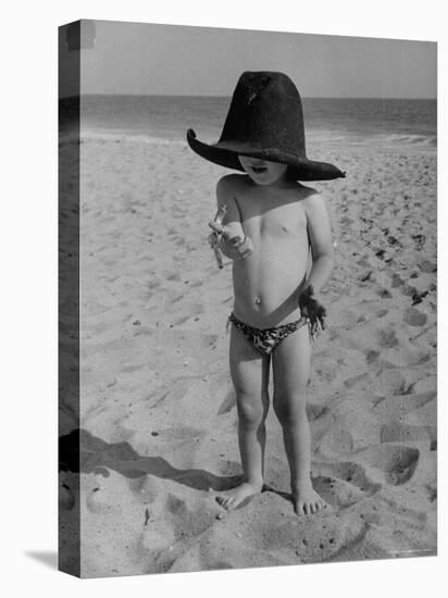 Little Boy at the Beach Wearing a Oversized Cowboy Hat Playing with a Toy Pistol-Ralph Crane-Stretched Canvas