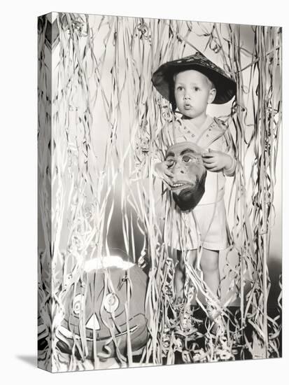 Little Boy in Halloween Costume Holding Mask Standing by Streamers-null-Stretched Canvas