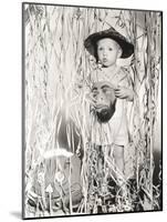 Little Boy in Halloween Costume Holding Mask Standing by Streamers-null-Mounted Photo