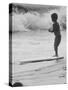 Little Boy Standing on a Surf Board Staring at the Water-Allan Grant-Stretched Canvas