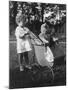 Little Girl Pushes Her Teddy Bear Around in a Pram-null-Mounted Photographic Print