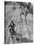 Little Girl Riding Her Tricycle, Leading Francis the Mule-Allan Grant-Stretched Canvas