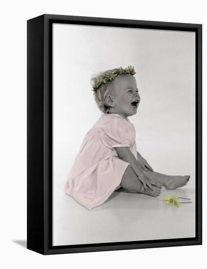 Little Girl Sitting and Laughing with a Floral Ring on Head and Two Flowers in Front of Her-Nora Hernandez-Framed Stretched Canvas