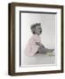 Little Girl Sitting and Laughing with a Floral Ring on Head and Two Flowers in Front of Her-Nora Hernandez-Framed Giclee Print