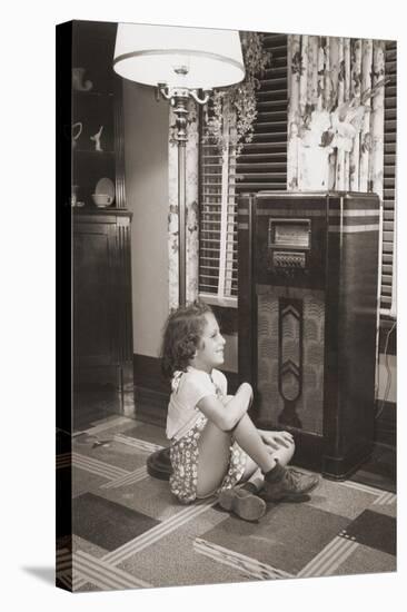 Little Girl Smiles as She Enjoys a Radio Program in the 1930s-null-Stretched Canvas