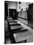 Looking Down Row of Empty Scarred Old Fashioned Desks in Schoolroom-Walter Sanders-Stretched Canvas