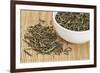 Loose Leaf Sencha Green Tea in a White China Cup and Spilled over Bamboo Mat-PixelsAway-Framed Photographic Print