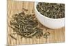 Loose Leaf Sencha Green Tea in a White China Cup and Spilled over Bamboo Mat-PixelsAway-Mounted Photographic Print