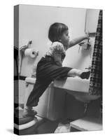 Lori Mckone in Bathroom Reaching for Toothbrush-null-Stretched Canvas