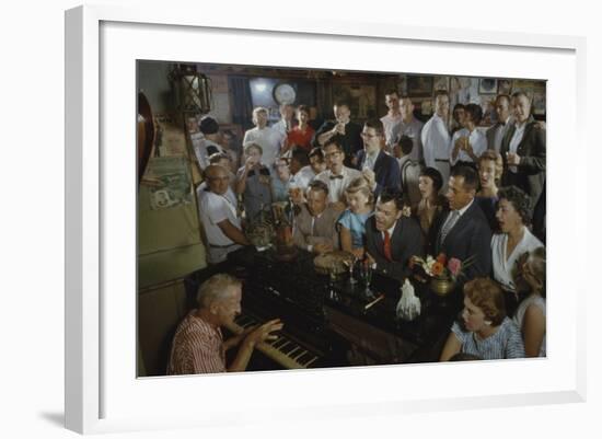 Low-Angle View of a Group of People as They Sing Along with a Pianist in a Unidentified Bar, 1959-Yale Joel-Framed Photographic Print