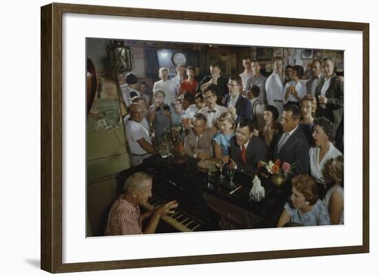 Low-Angle View of a Group of People as They Sing Along with a Pianist in a Unidentified Bar, 1959-Yale Joel-Framed Photographic Print