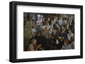 Low-Angle View of a Group of People as They Sing Along with a Pianist in a Unidentified Bar, 1959-Yale Joel-Framed Photographic Print