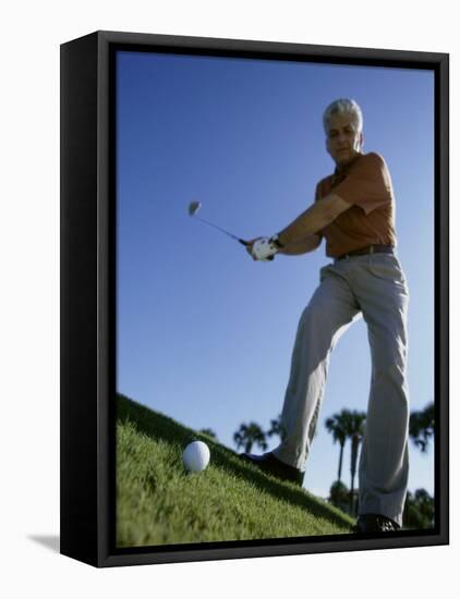 Low Angle View of a Senior Man Swinging a Golf Club-null-Framed Stretched Canvas