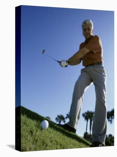 Low Angle View of a Senior Man Swinging a Golf Club-null-Stretched Canvas