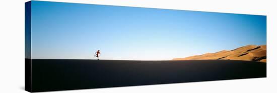 Low Angle View of a Woman Running in the Desert, Great Sand Dunes National Monument, Colorado, USA-null-Stretched Canvas