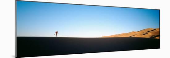 Low Angle View of a Woman Running in the Desert, Great Sand Dunes National Monument, Colorado, USA-null-Mounted Photographic Print