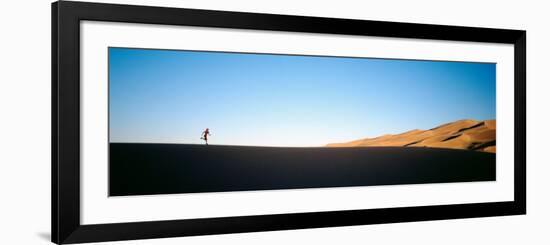 Low Angle View of a Woman Running in the Desert, Great Sand Dunes National Monument, Colorado, USA-null-Framed Photographic Print