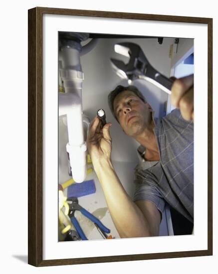 Low Angle View of a Young Man Checking the Plumbing with a Flashlight-null-Framed Photographic Print