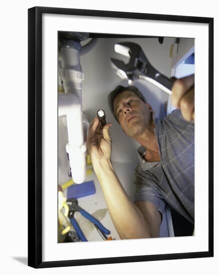 Low Angle View of a Young Man Checking the Plumbing with a Flashlight-null-Framed Photographic Print