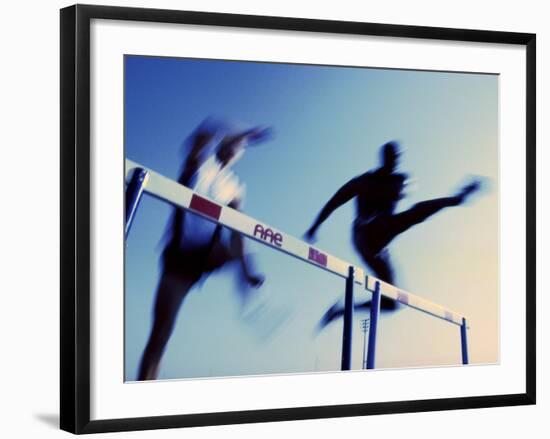 Low Angle View of Athletes Jumping over Hurdles-null-Framed Photographic Print