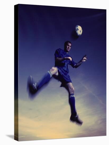 Low Section View of a Soccer Player Jumping in Mid Air to Head a Soccer Ball-null-Stretched Canvas