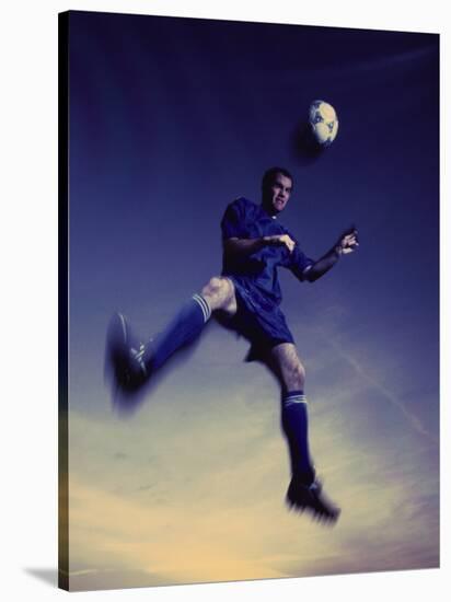 Low Section View of a Soccer Player Jumping in Mid Air to Head a Soccer Ball-null-Stretched Canvas