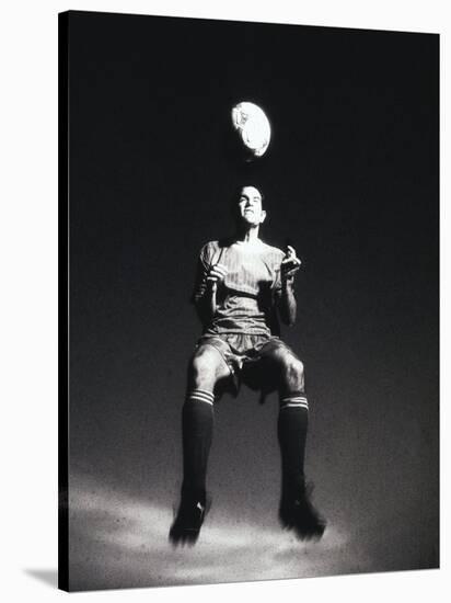 Low Section View of a Soccer Player Jumping in Mid Air to Head a Soccer Ball-null-Stretched Canvas