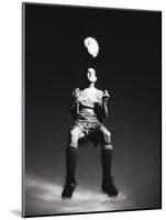 Low Section View of a Soccer Player Jumping in Mid Air to Head a Soccer Ball-null-Mounted Photographic Print