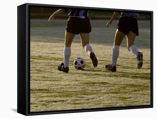 Low Section View of Two Female Soccer Players Kicking a Soccer Ball-null-Framed Stretched Canvas