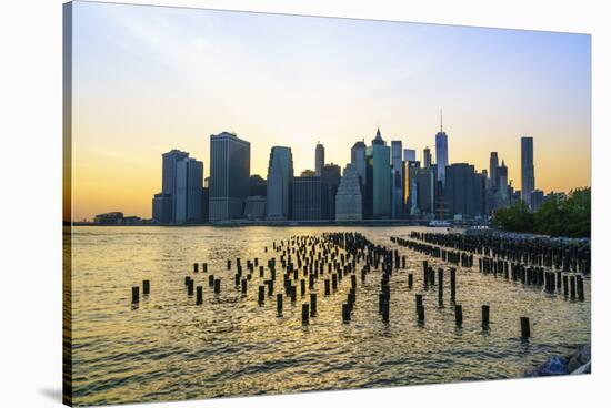 Lower Manhattan skyline across the East River at sunset, New York City, New York, United States of -Fraser Hall-Stretched Canvas