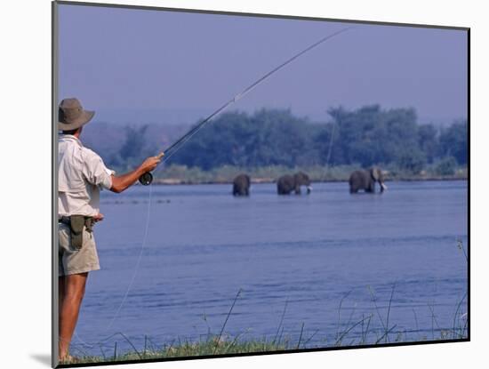 Lower Zambezi National Park, Fly-Fishing for Tiger Fish on the Zambezi River Against a Backdrop of -John Warburton-lee-Mounted Photographic Print