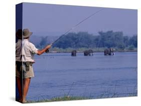 Lower Zambezi National Park, Fly-Fishing for Tiger Fish on the Zambezi River Against a Backdrop of -John Warburton-lee-Stretched Canvas