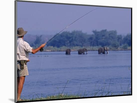 Lower Zambezi National Park, Fly-Fishing for Tiger Fish on the Zambezi River Against a Backdrop of -John Warburton-lee-Mounted Photographic Print