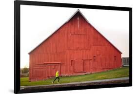 Male Runner Runs Along A Gravel Trail In Front Of Bright Red Barn In UI Arboretum In Moscow, Idaho-Ben Herndon-Framed Photographic Print