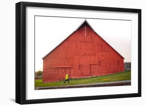 Male Runner Runs Along A Gravel Trail In Front Of Bright Red Barn In UI Arboretum In Moscow, Idaho-Ben Herndon-Framed Photographic Print