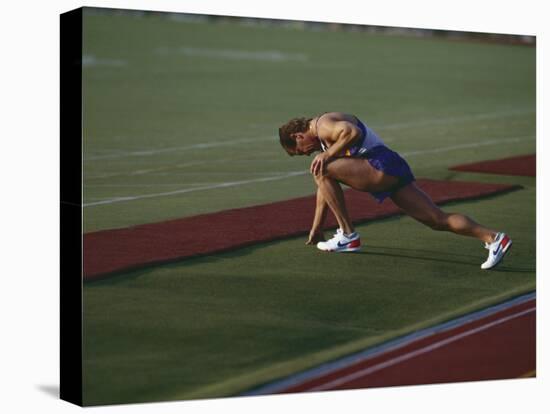 Male Runners Stetching before Competing in a Track Race-null-Stretched Canvas