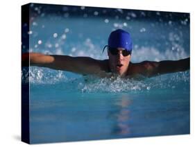 Male Swimmer Competing in Abutterfly Race-null-Stretched Canvas