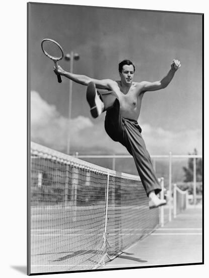 Male Tennis Player Jumping over Net-null-Mounted Photo