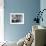 Man and Woman Standing in a Kitchen While She is Ironing His Pants and He is Behind a Curtain-null-Framed Photo displayed on a wall