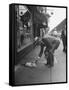 Man Bending over to Touch Cat Sitting on Sidewalk-Nina Leen-Framed Stretched Canvas