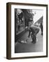 Man Bending over to Touch Cat Sitting on Sidewalk-Nina Leen-Framed Premium Photographic Print