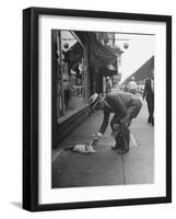 Man Bending over to Touch Cat Sitting on Sidewalk-Nina Leen-Framed Premium Photographic Print